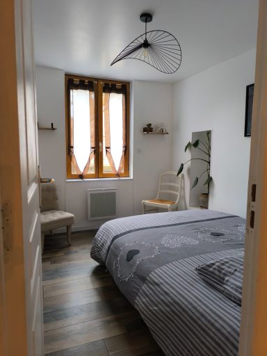 Chambre au rez-de-chaussée vue sur la rivière Chambre lumineuse avec lit double, fenêtres en bois et décoration moderne.